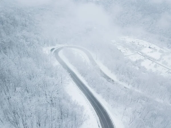 Drones Eye View - Güney Rusya 'daki yüksek dağ geçidinden gelen kış virajı yolu. Yoğun ormanda harika bir yolculuk..