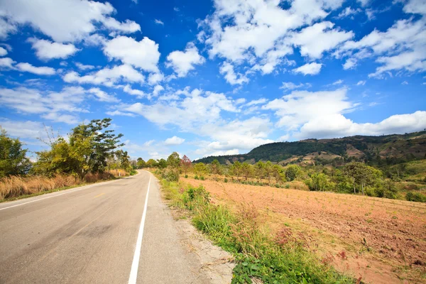 Asphalt road and clouds on blue sky — Stock Photo, Image
