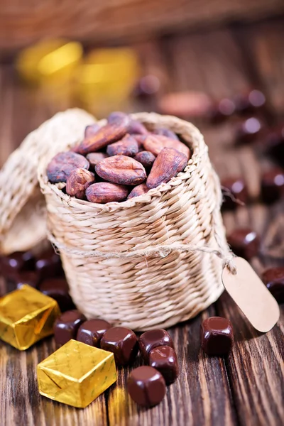 Cocoa beans and chocolate candies — Stock Photo, Image