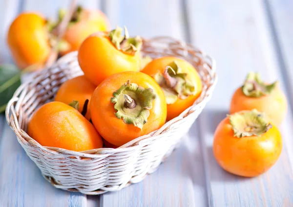 Ripe persimmons in basket — Stock Photo, Image