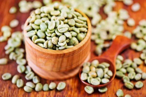 Green coffee beans and spoon — Stock Photo, Image