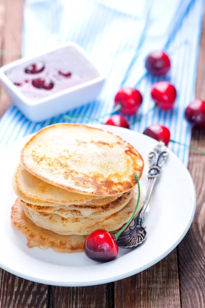 Pannkakor med körsbär på plattan — Stockfoto