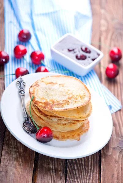 Pancakes with cherries on the plate — Stock Photo, Image