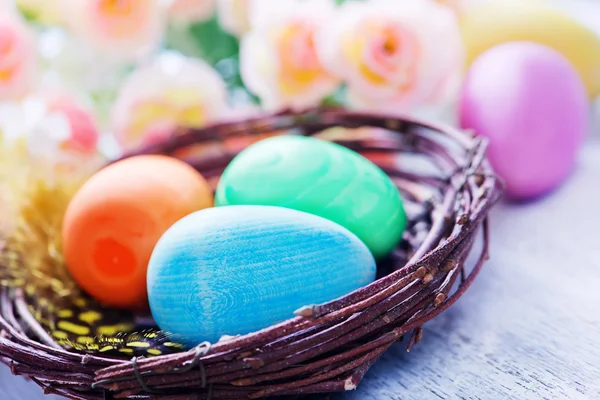 Huevos de Pascua en nido y flores — Foto de Stock