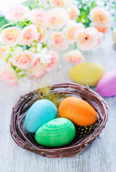 Easter eggs in nest and flowers — Stock Photo, Image