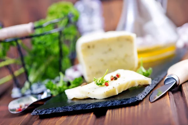 Cheese on board and knife — Stock Photo, Image