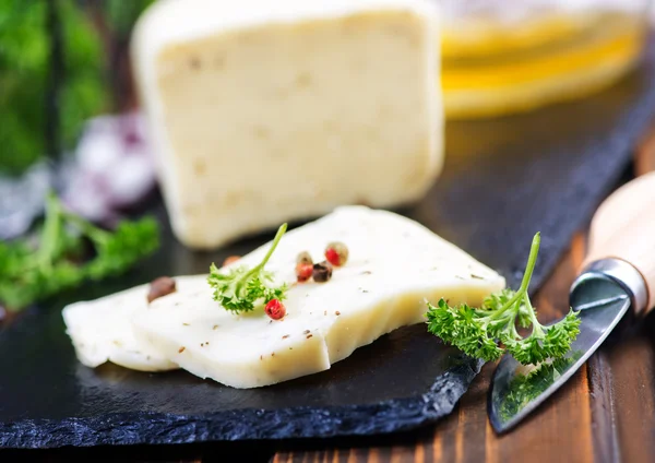 Cheese on board and knife — Stock Photo, Image