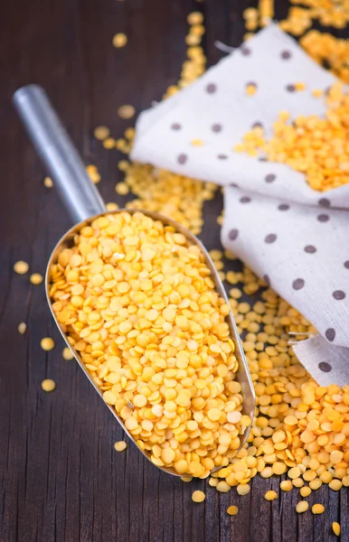 Yellow lentil in metal spoon — Stock Photo, Image