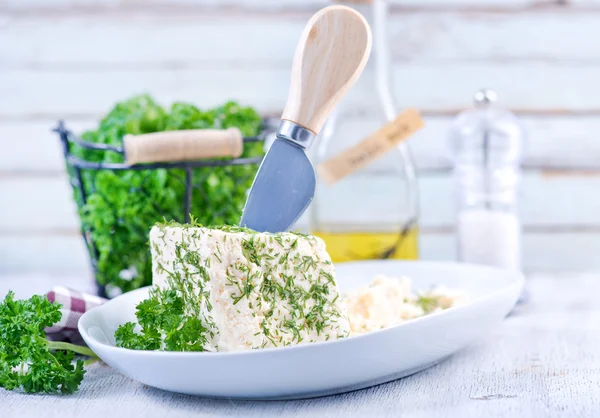 Queijo na placa branca com faca — Fotografia de Stock