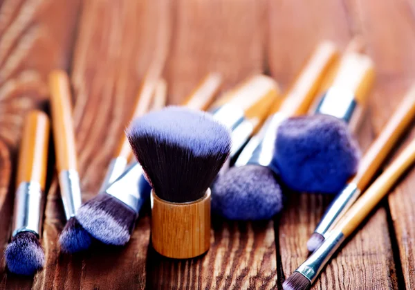 Kosmetikpinsel auf Holztisch — Stockfoto