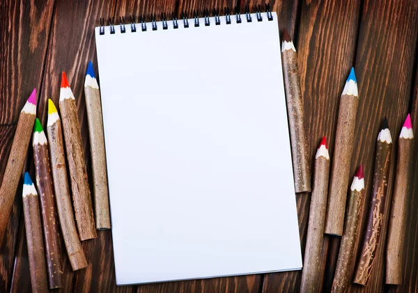 Пустой блокнот и цветные карандаши — стоковое фото