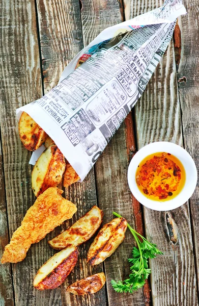 Pescado y patatas fritas en la mesa — Foto de Stock