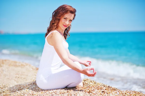 Young woman meditating on the beach — Stock Photo, Image