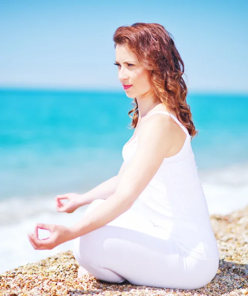 Young woman meditating on the beach — Stock Photo, Image