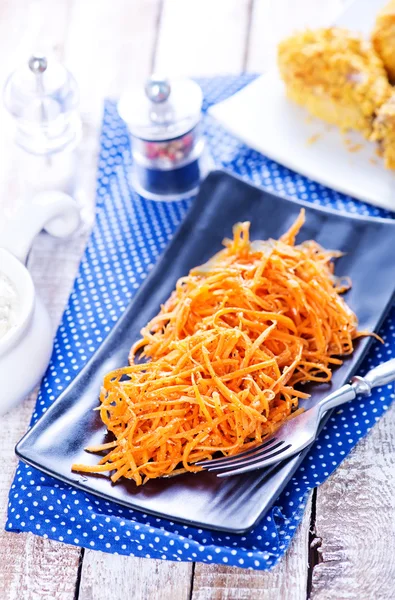 Salad from carrot on black plate — Stock Photo, Image