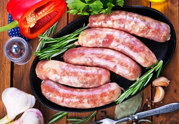 Raw sausages on plate — Stock Photo, Image