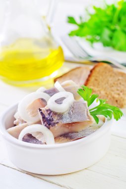 Mavi plaka üzerinde soğan ile ringa balığı 