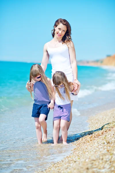 Mujer con niñas en la playa — Foto de Stock