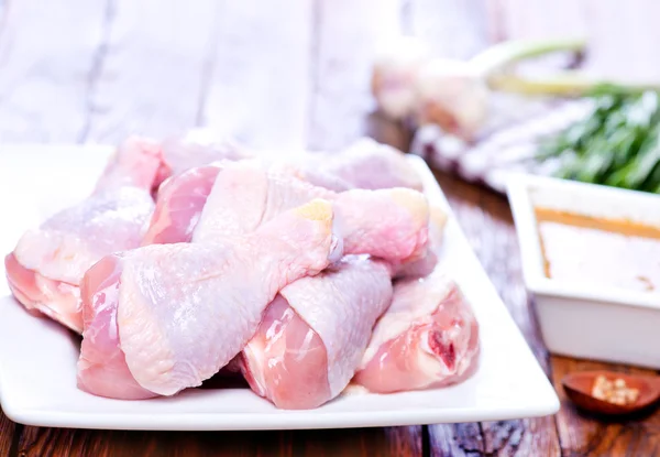 Raw chicken legs on plate — Stock Photo, Image