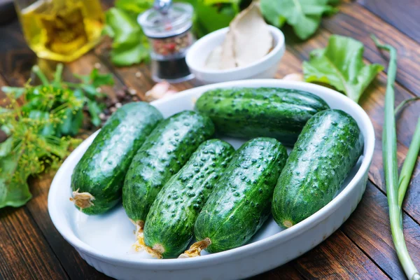 Komkommers met kruiden op tafel — Stockfoto