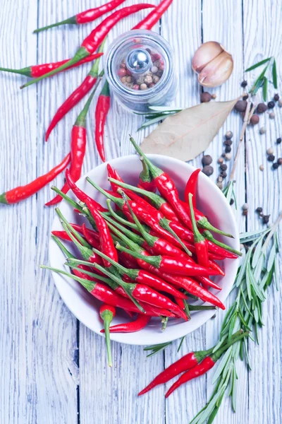 Chilli peppers and spices on table — Stock Photo, Image