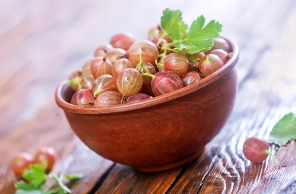 Bowl of gooseberries on table — Stock Photo, Image