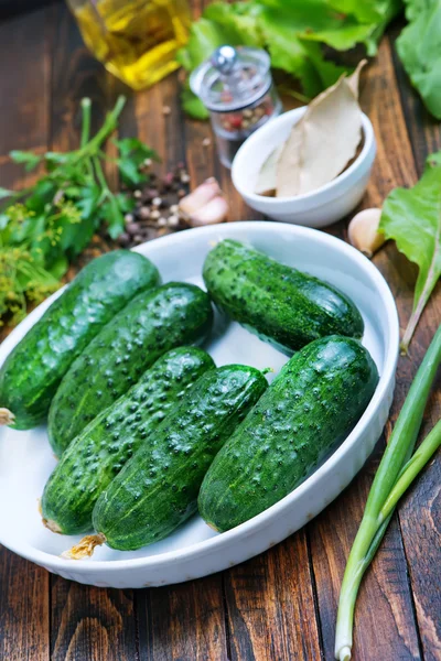 Komkommers met kruiden op tafel — Stockfoto