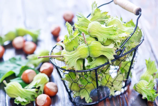 Haselnüsse mit Blättern auf dem Tisch — Stockfoto