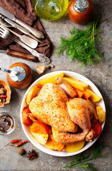Whole baked chicken with crusty skin glazed with honey. Chicken with potato and carrot