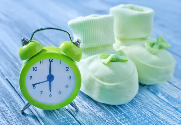 Clock and baby socks — Stock Photo, Image