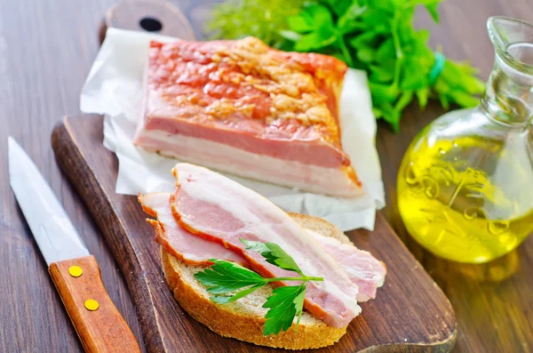 Stukken van gerookte varkensvlees bacon — Stockfoto