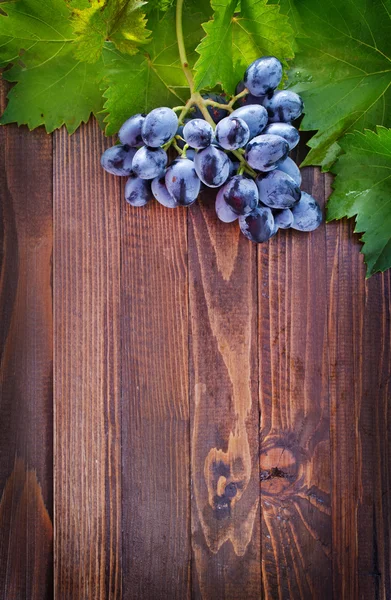 Viinirypäle puupohjalla — kuvapankkivalokuva
