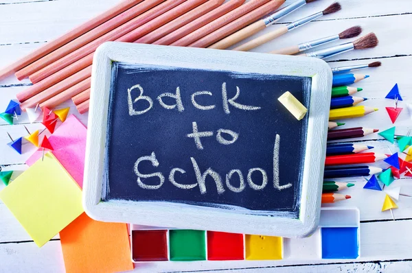 Blackboard and school supplies — Stock Photo, Image