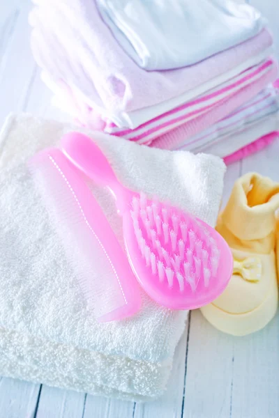 Hair brushes and baby clothes — Stock Photo, Image