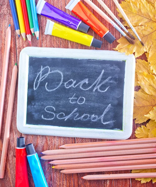 Chalkboard, school supplies and autumn leaves — Stock Photo, Image