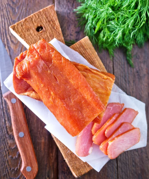 Smoked meat on wooden board — Stock Photo, Image