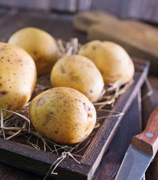 Сырой картофель в деревянной коробке — стоковое фото