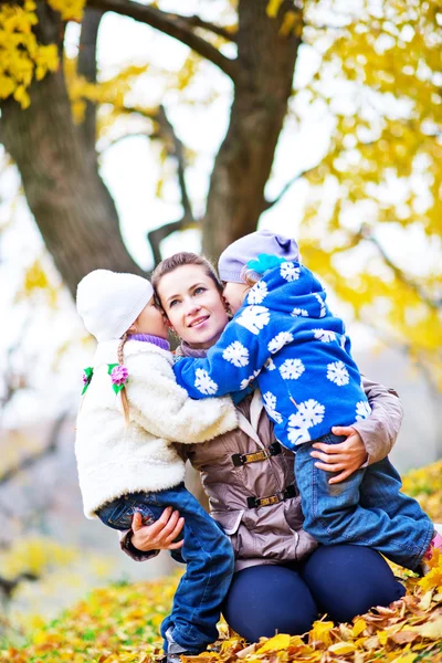 Mother and doughters in autumn park — Stock Photo, Image