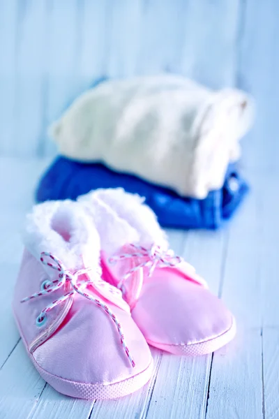 De kleren van de baby op een tafel — Stockfoto