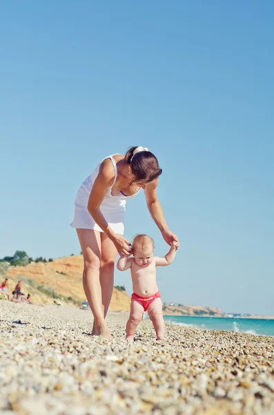 Frau mit Baby am Strand — Stockfoto