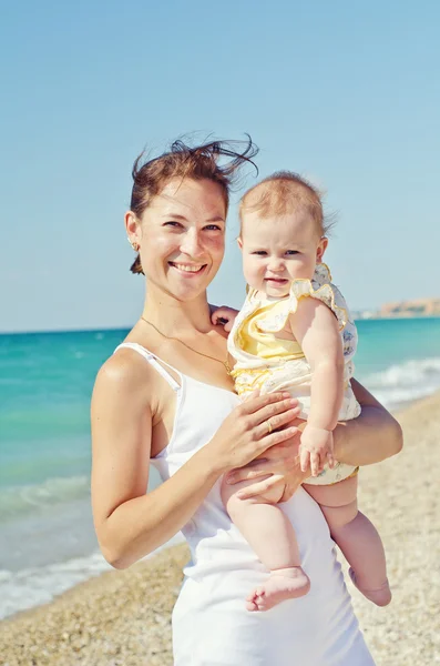 妇女抱着婴儿在海滩上 — 图库照片