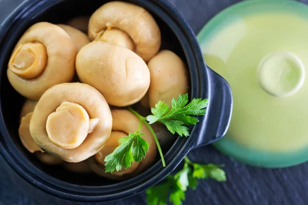 Mushrooms in black bowl — Stock Photo, Image