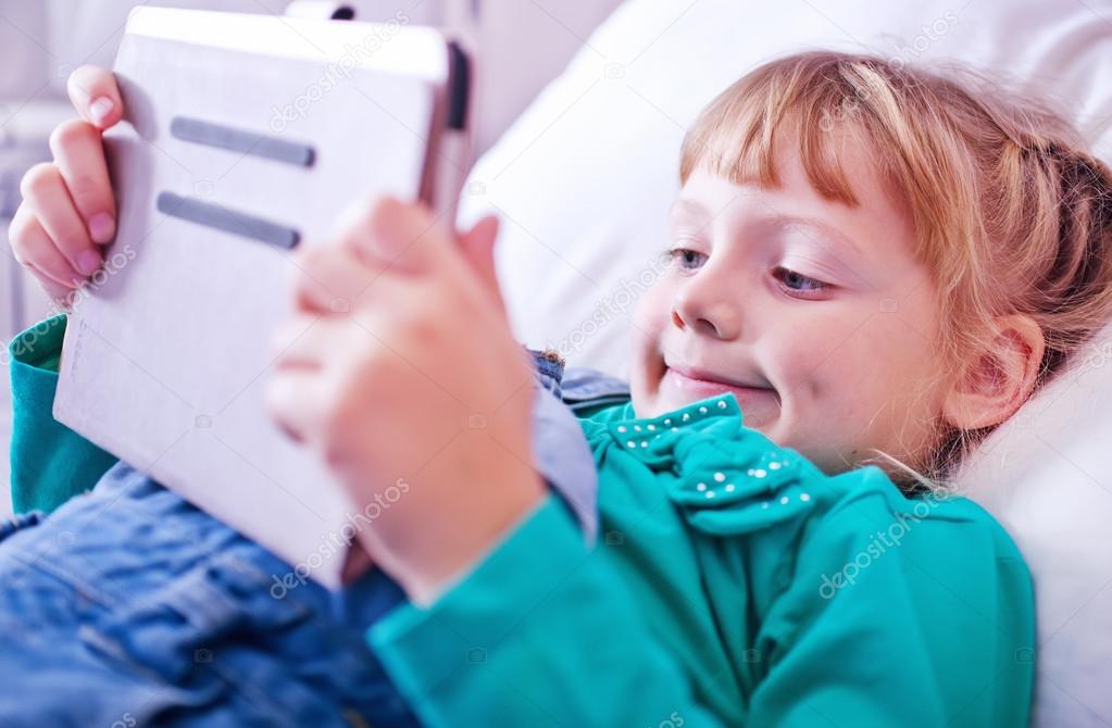 Pre-teen child playing on tablet pc