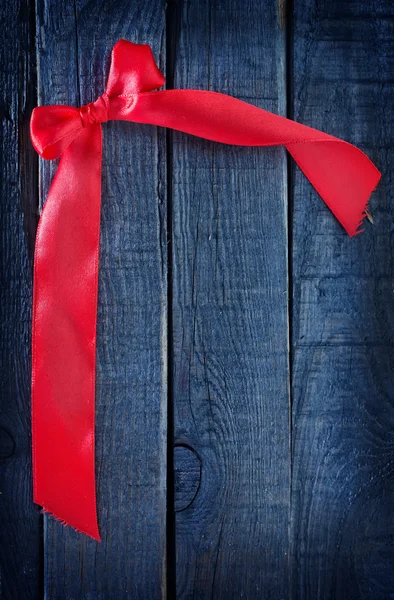 Red ribbon on wooden background — Stock Photo, Image