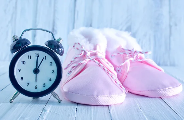 Babyschuhe und Uhr — Stockfoto