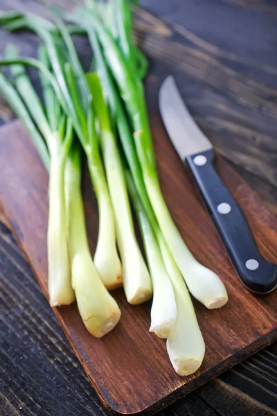 Green onion on wooden board — Stock Photo, Image