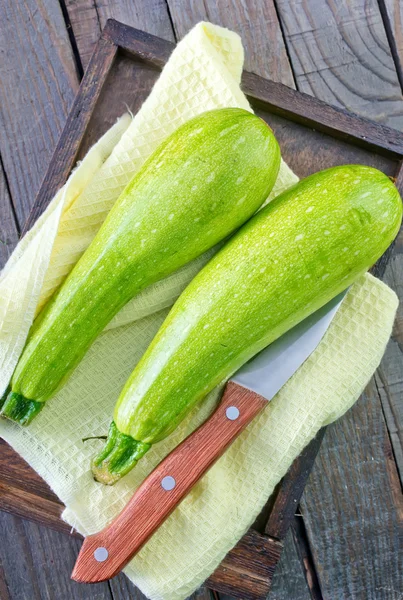 Raw zucchini on wooden tray — Stock Photo, Image