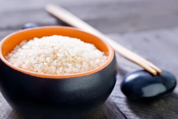 Surowy ryż w misce i azjatyckie laski — Zdjęcie stockowe