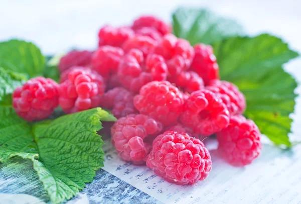 Färska hallon och gröna blad — Stockfoto