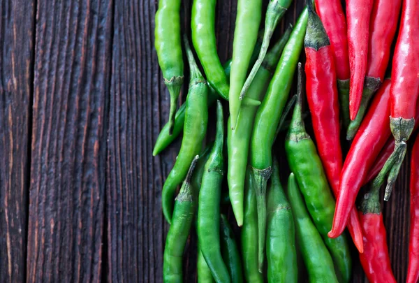 Chilli peppers on the wooden table — Stock Photo, Image